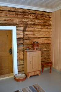 1700-tallsdøra mellom stua og soverommet har fått selskap av et gammelt skap, en dnydelig dekorert grøtdall, en mjølkebunk og en trebenet fjøskrakk. 